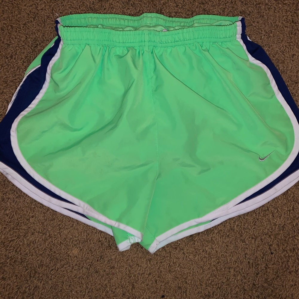 Neon green Nike shorts with white and blue strip